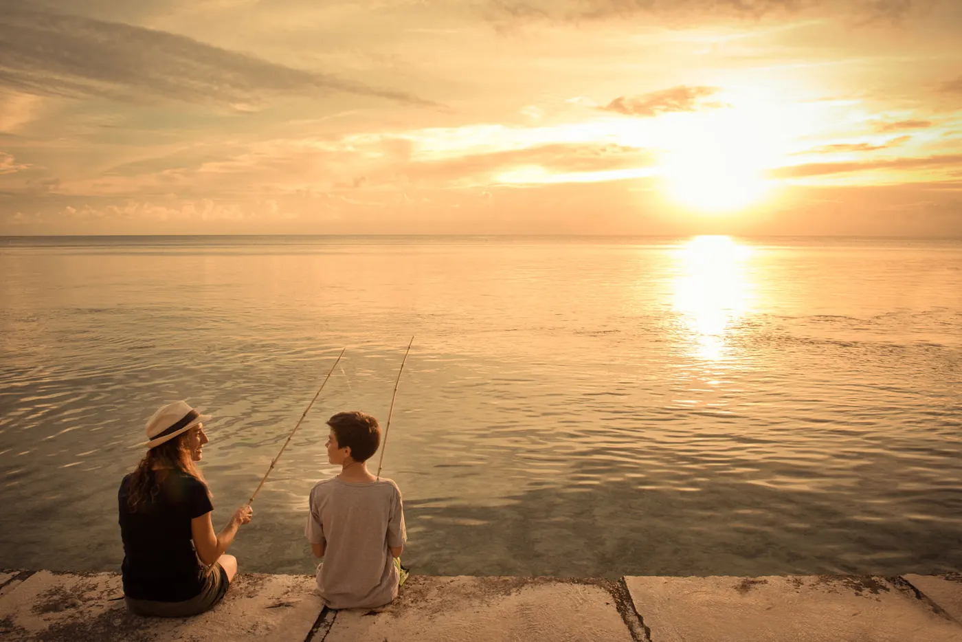 Due persone ammirano il tramonto sull'oceano a Rangiroa
